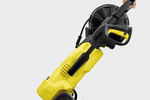 Yellow and black pressure washer with hose reel on a white background