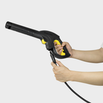 Person holding a black and yellow pressure washer gun on a white background