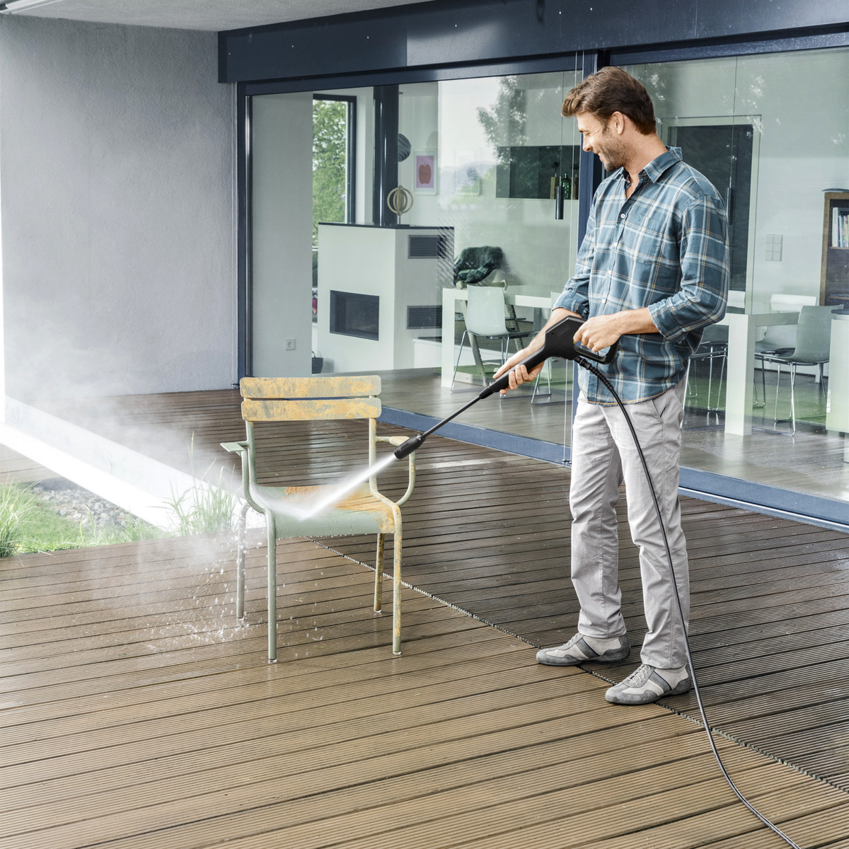 Man cleaning a wooden deck with a pressure washer