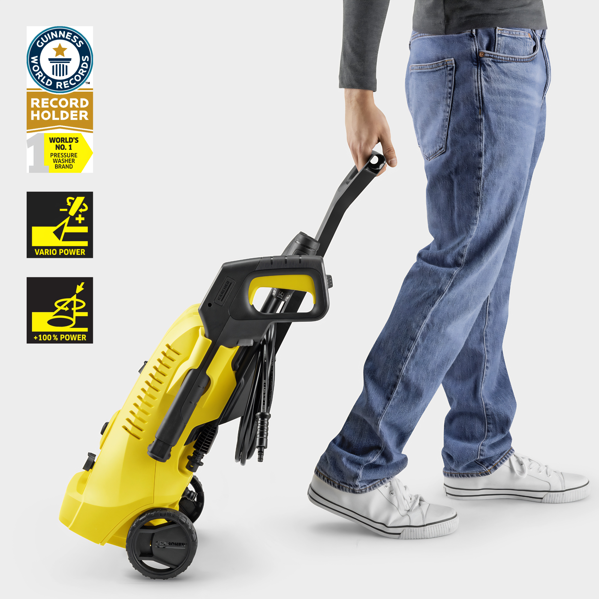 Person holding a yellow and black pressure washer with brand logos on a white background