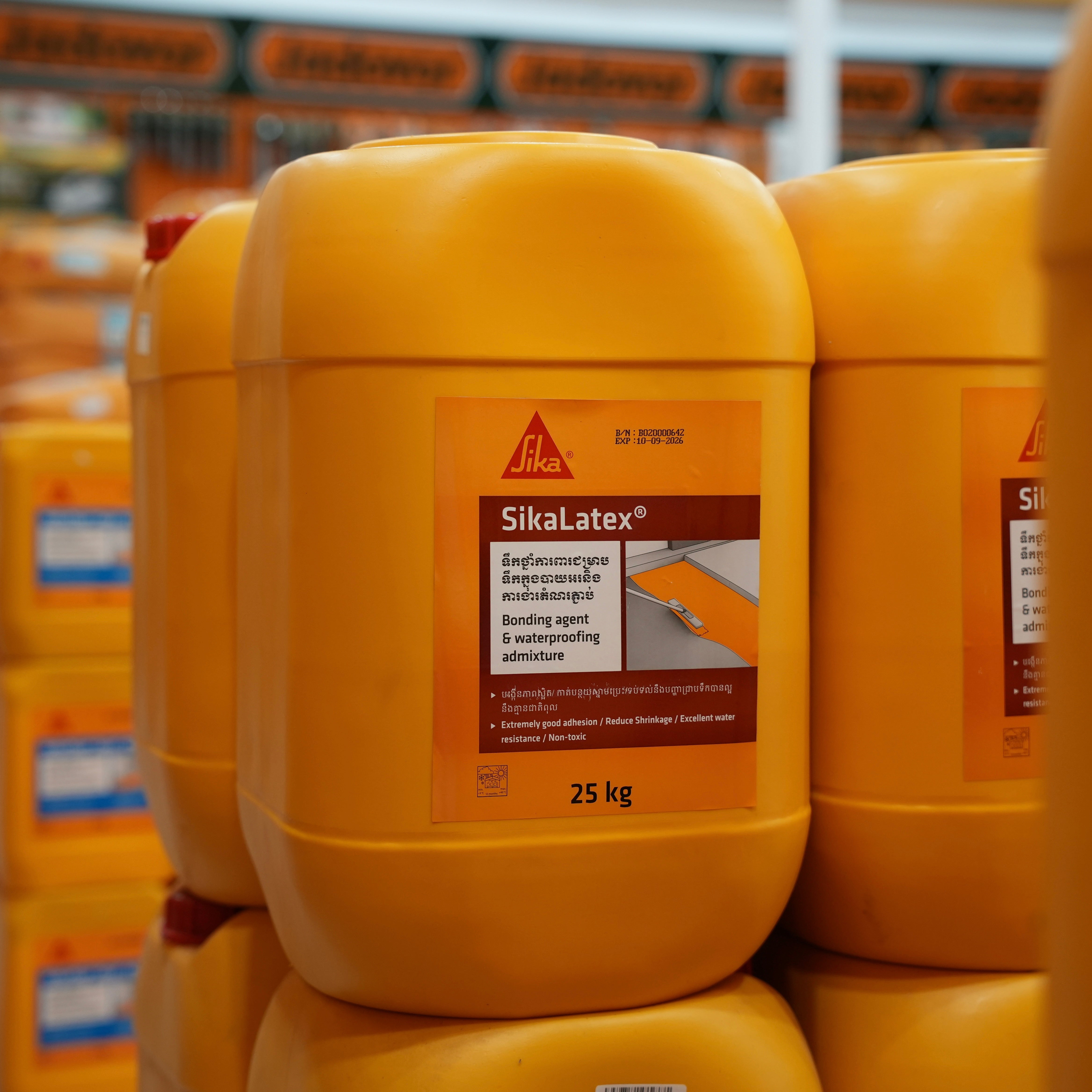 Yellow SikaLatex containers stacked in a warehouse setting