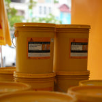 Two yellow buckets with Sika labels on a blurred background