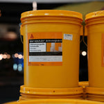 Yellow buckets with Sika Igolflex label on a blurred background