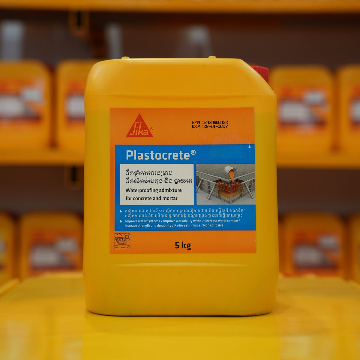 Yellow container of Plastocrete with Sika branding on a blurred background