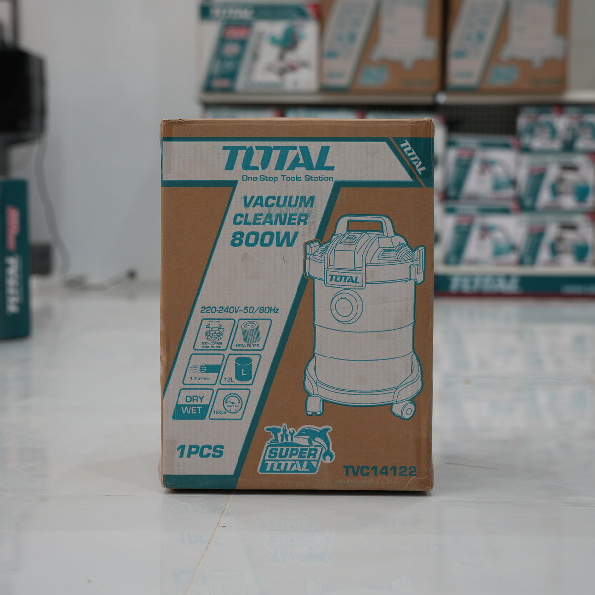 Total brand vacuum cleaner box on a store floor with blurred shelves in the background